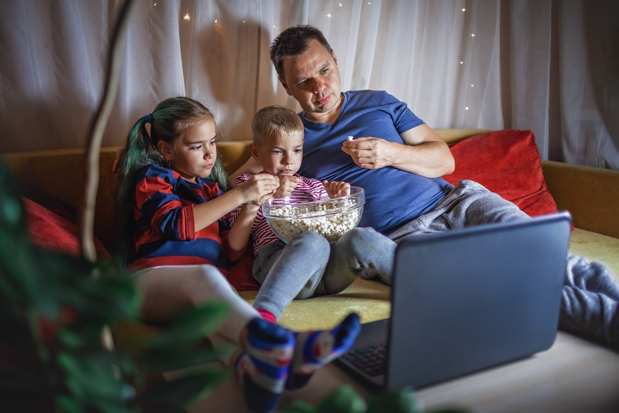 family-movie-night-father-with-kids-watching-movie-with-popcorn-by-laptop-indoor-lifestyle.jpg